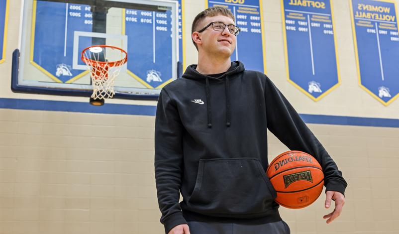 Jacob Perks, posing with a basketball in the Hennessey Gym