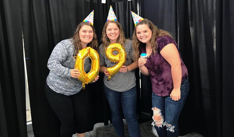 Macey and friends posing with 90 balloons for the university's anniversary