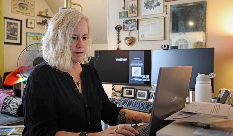 Jennifer typing on a laptop